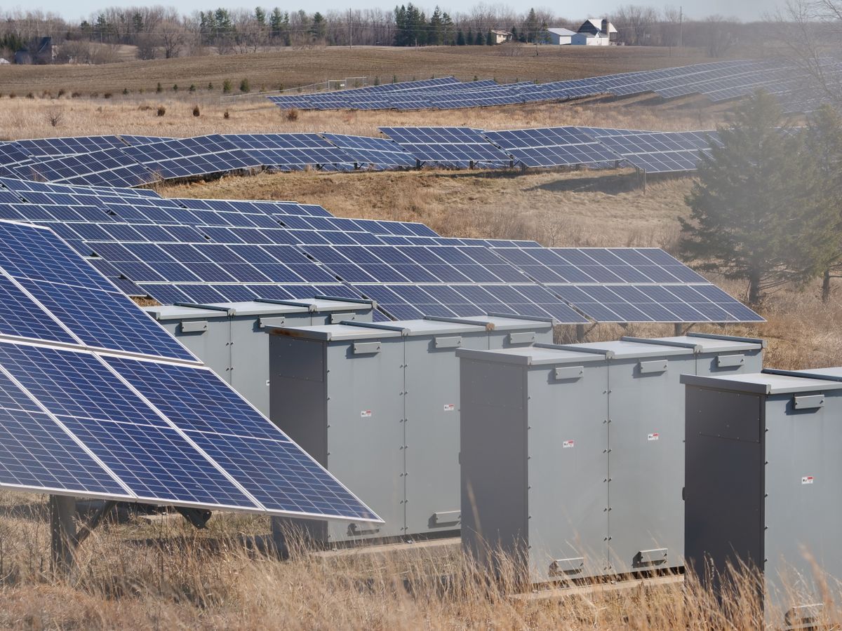 Campo fotovoltaico a terra con armadi tecnici tra le file di pannelli